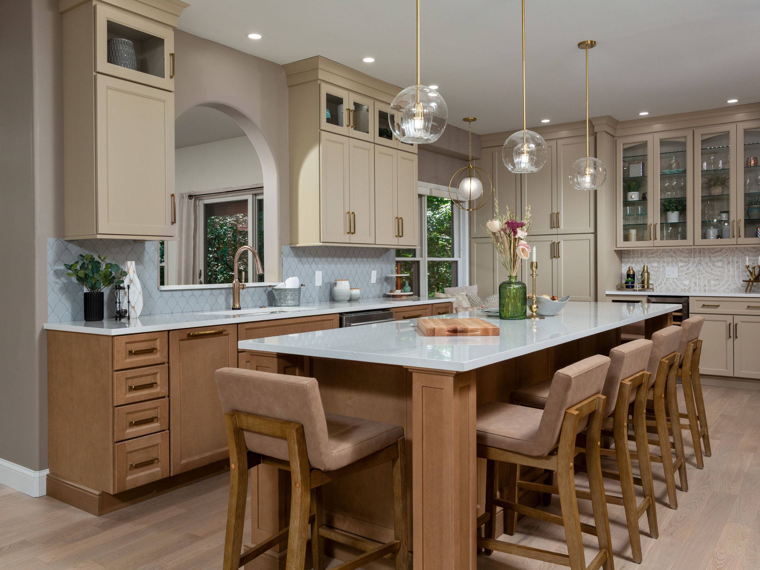 Large quartz kitchen island with seating, brass pendant lights, and custom cabinetry in transitional kitchen design.seating