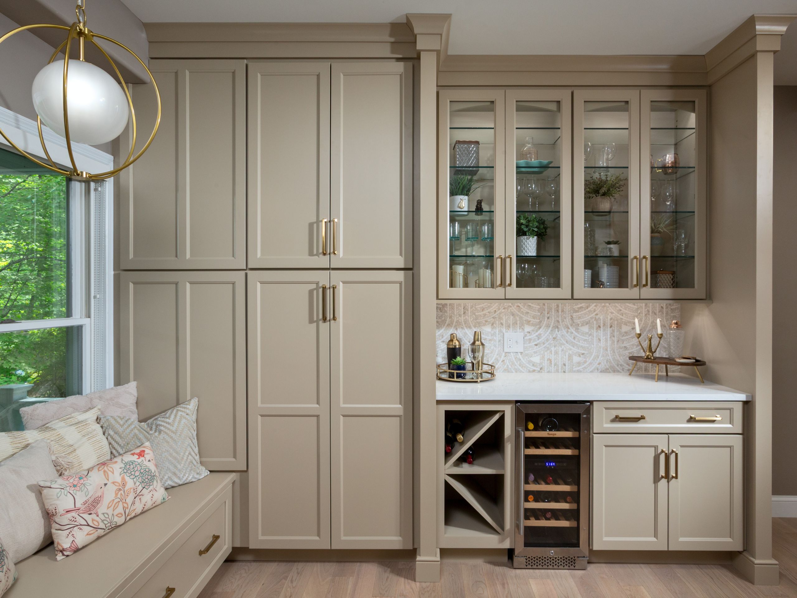 Built-in beverage center with wine refrigerator, glass upper cabinets, and decorative tile backsplash.remodel